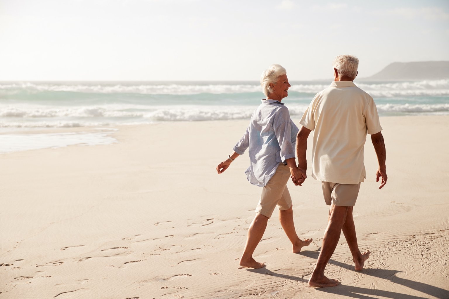 Elderly couple walking on the beach